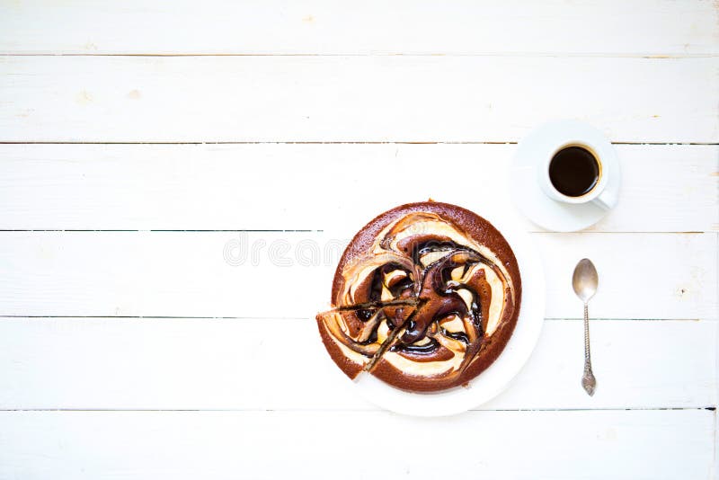 Piece of chokolate cake and cup of coffee on white wooden table. Top view image of restaurant or cafe menu background