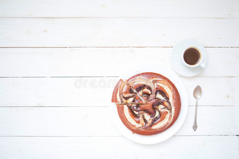 Piece of chokolate cake and cup of coffee on white wooden table. Top view image of restaurant or cafe menu background