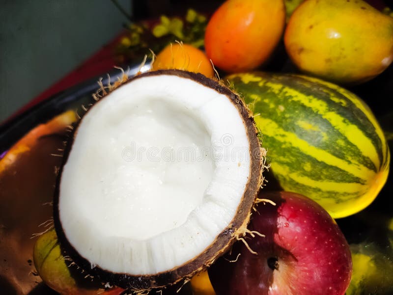 A piece of coconut placed on fruits. stock image