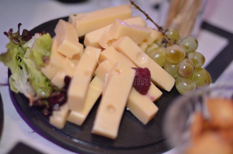 A Piece and Cubes of Swiss Cheese on a Cutting Board Stock Photo