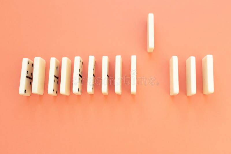 A piece of dominoes is up while the rest are lined up to make a domino effect. Interpersonal distance concept stock images