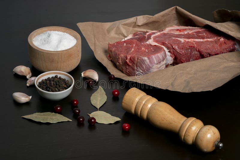 https://thumbs.dreamstime.com/b/piece-fresh-raw-meat-wrapped-kraft-paper-garlic-cloves-bay-leaf-spices-table-close-up-237396673.jpg
