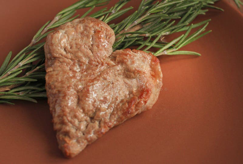 A Piece of Fried Pork Meat in the Shape of a Heart on a Plate Stock