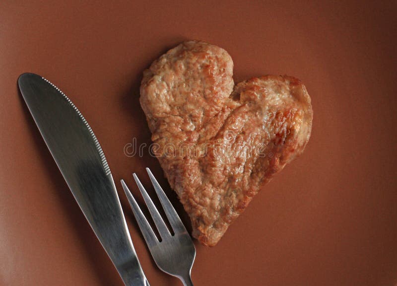 A Piece of Fried Pork Meat in the Shape of a Heart on a Plate Stock