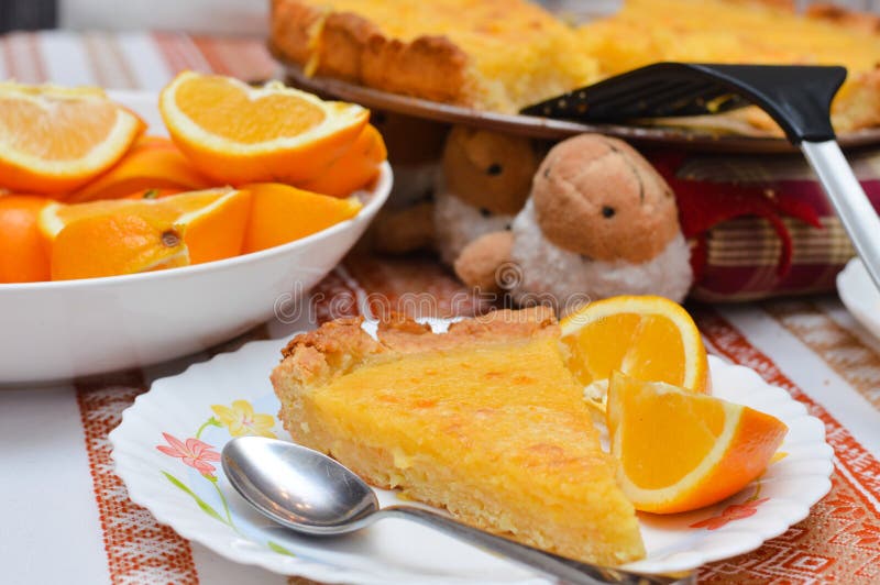 Piece of Lemon and almond pie on plate with oranges