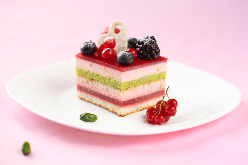 Piece of Multilayered Berry and Pistachio Mousse Cake Stock Photo