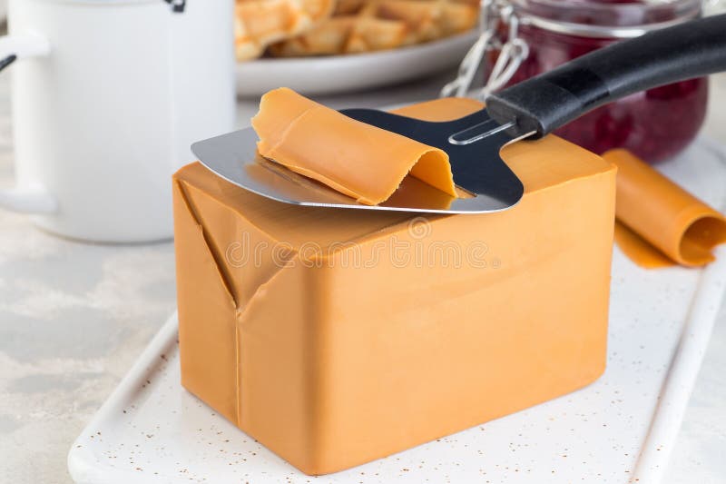 Piece of Norwegian Brown Cheese with Cheese Slicer, Horizontal, Closeup