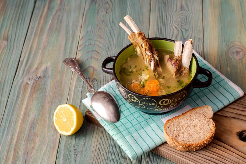 Sheep soup in a bowl close-up. Pieces of bread and sheep, hot, delicious soup in a bowl on a wooden table close-up Greek cuisine stock image Sheep soup in a bowl close-up. Pieces of bread and sheep, hot, delicious soup in a bowl on a wooden table close-up Greek cuisine stock image