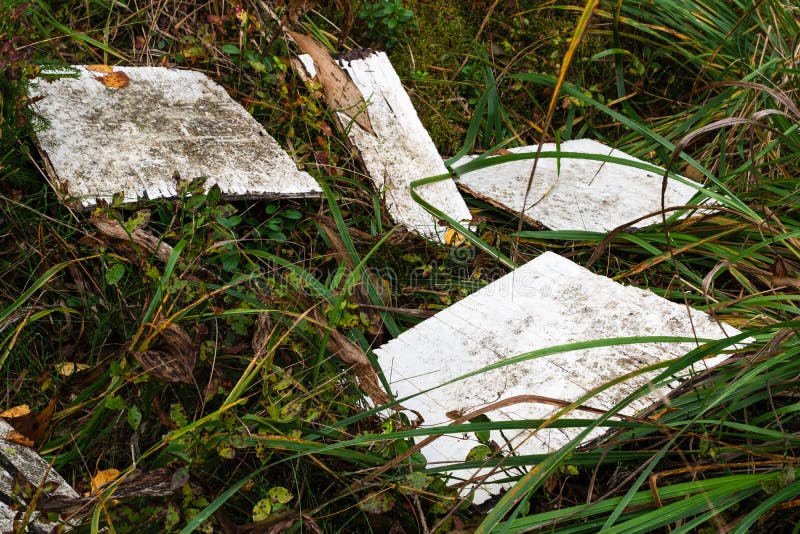Pieces of broken empty white wooden sign laying on forest floor stock images