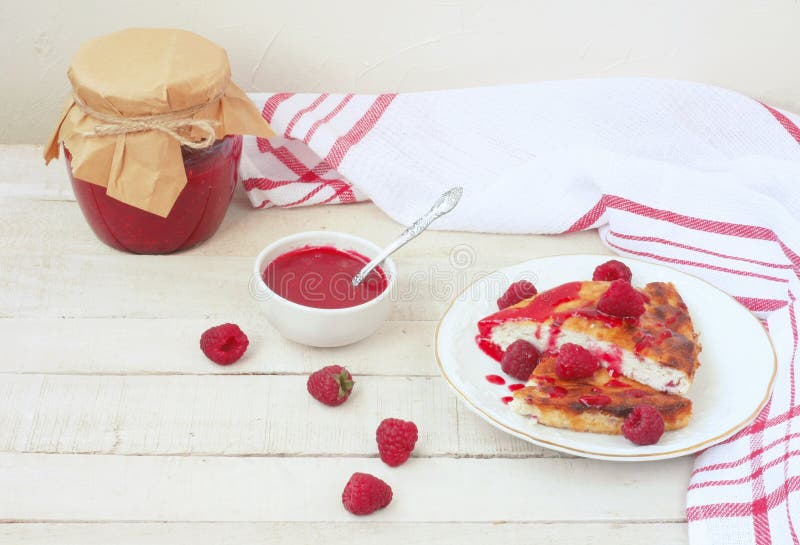 Pieces of curd pudding with raspberry jam in white plate