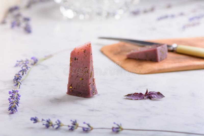 Pieces of lavender cheese and lavender flowers on a white marble worktop stock photo Pieces of lavender cheese and lavender flowers on a white marble worktop stock photo