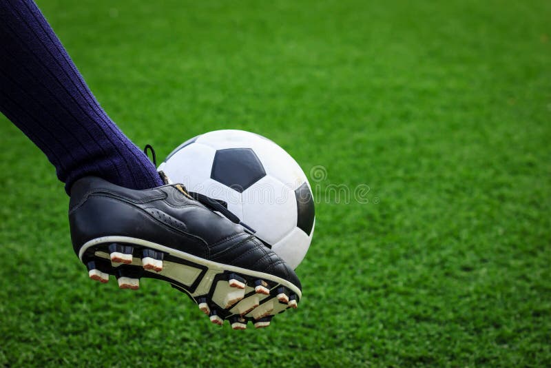 Piede che dà dei calci al pallone da calcio fotografia stock libera da diritti Piede che dà dei calci al pallone da calcio fotografia stock libera da diritti