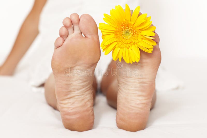 Woman foot with yellow flower between fingers. Woman foot with yellow flower between fingers