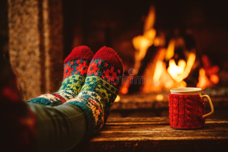 Piedi in calzini di lana dal camino di Natale La donna si distende