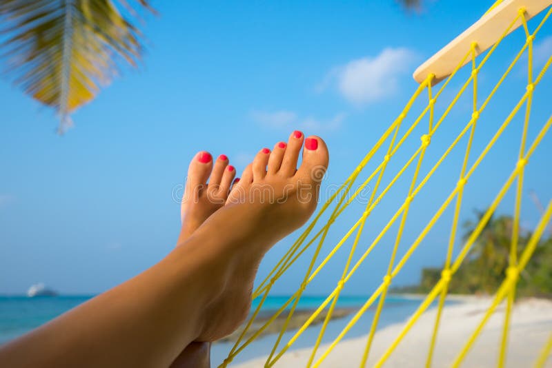 Piedi della donna in amaca sulla spiaggia immagini stock libere da diritti Piedi della donna in amaca sulla spiaggia immagini stock libere da diritti