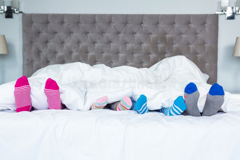 Piedi della famiglia che attaccano fuori dalla coperta fotografie stock libere da diritti Piedi della famiglia che attaccano fuori dalla coperta fotografie stock libere da diritti