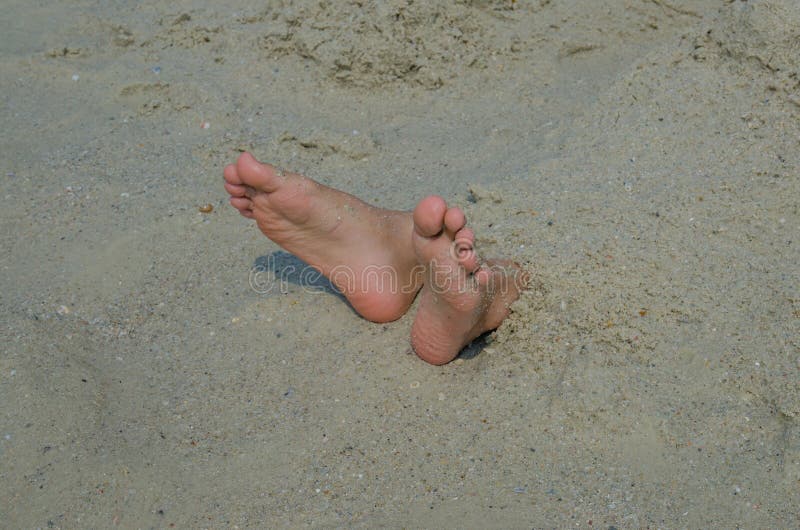 Piedi sepolti nella sabbia fotografia stock Piedi sepolti nella sabbia fotografia stock