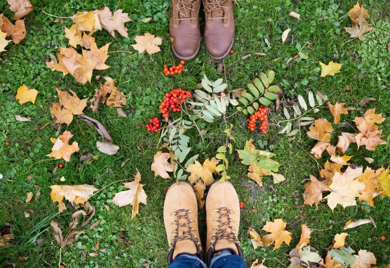 Piedi in stivali con le sorbe e le foglie di autunno immagini stock libere da diritti Piedi in stivali con le sorbe e le foglie di autunno immagini stock libere da diritti