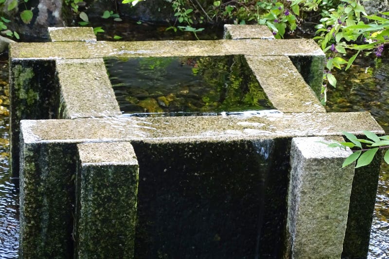 Piedra vieja bien llena de agua en un parque fotografía de archivo Piedra vieja bien llena de agua en un parque fotografía de archivo