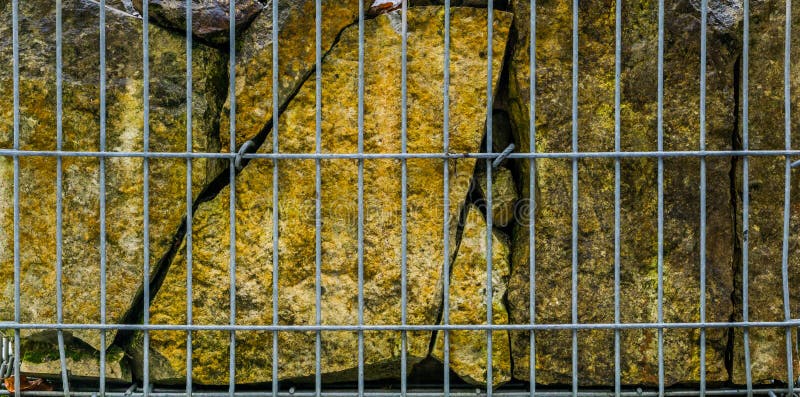 Piedras grandes detrás de una cerca del metal, decoración hermosa del jardín, fondo natural imagen de archivo libre de regalías Piedras grandes detrás de una cerca del metal, decoración hermosa del jardín, fondo natural imagen de archivo libre de regalías