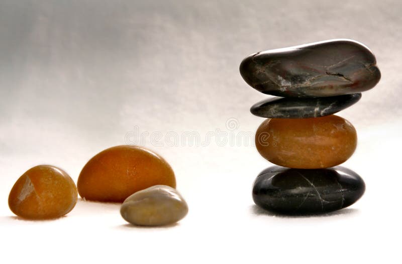 Eye level view of zen balanced stones, on textured light colored cloth. Eye level view of zen balanced stones, on textured light colored cloth