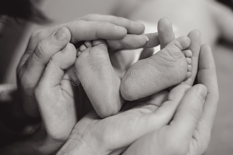Pieds de bébé dans des mains de mères photographie stock libre de droits Pieds de bébé dans des mains de mères photographie stock libre de droits