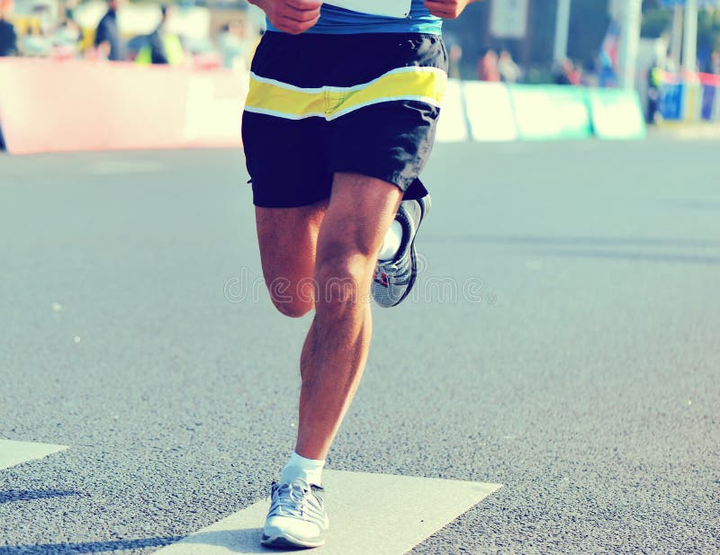 Pieds de coureur sur la route urbaine dans la course courante de marathon images libres de droits Pieds de coureur sur la route urbaine dans la course courante de marathon images libres de droits