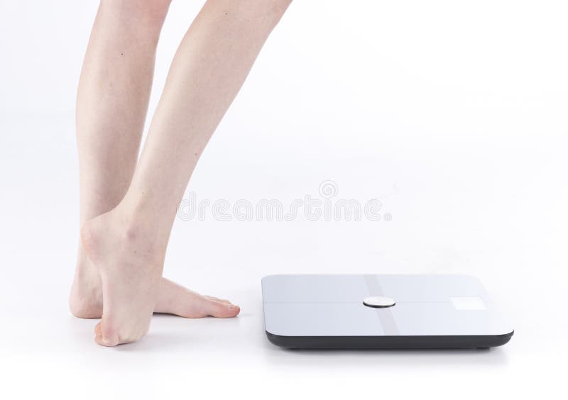 Pieds femelles et jambes se tenant près de la balance image stock Pieds femelles et jambes se tenant près de la balance image stock
