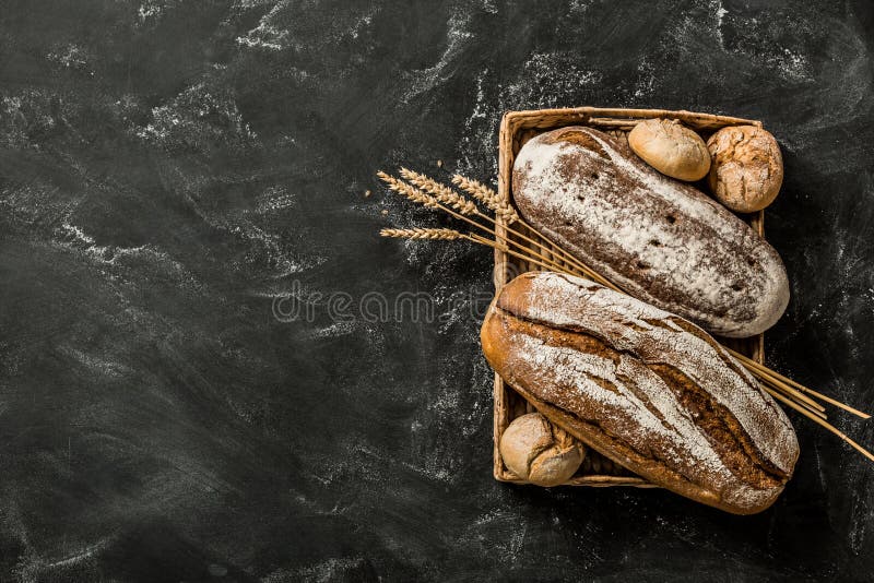 Piekarnia - nieociosani skorupiaści bochenki chleb i babeczki na czerni