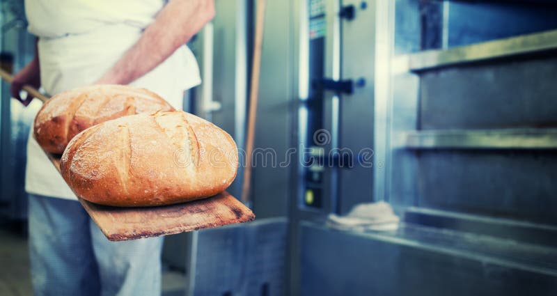 Piekarz w piekarni z chlebem na łopacie