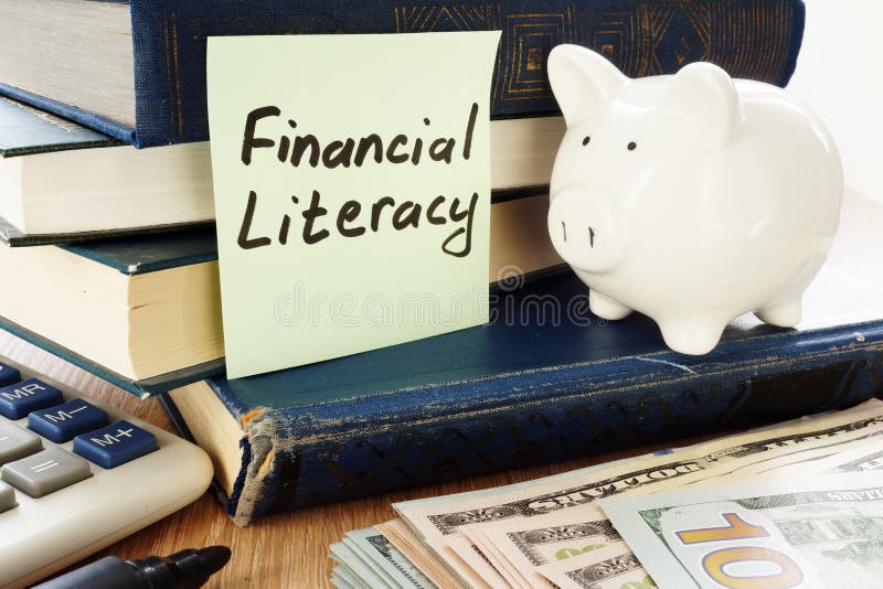 Financial Literacy written on a memo stick and piggy bank as savings symbol. Financial Literacy written on a memo stick and piggy bank as savings symbol.