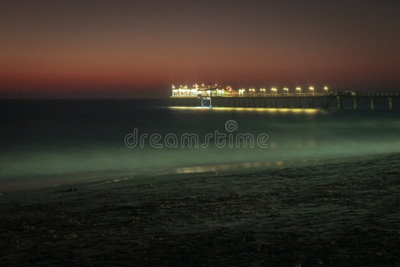 Pier on the Atlantic Ocean in Swakompund, Namibia. Beautiful sunset with a bright sky and soft gentle water