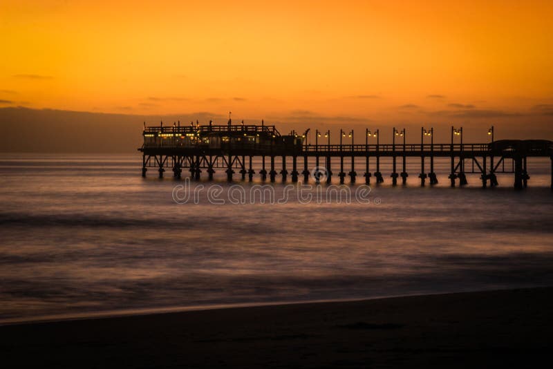 Pier on the Atlantic Ocean in Swakompund, Namibia. Beautiful sunset with a bright sky and soft gentle water