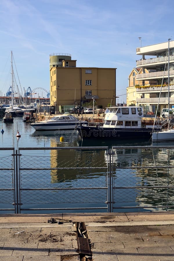 Pier with Docked Boats Seen from a Pavement on a Sunny Day Editorial