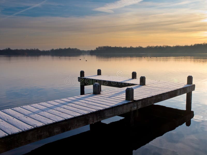 Pier at lake during wintertime sunrise