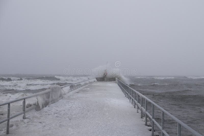 Pier at Lake Ontario during strong wind and heavy snow storm.