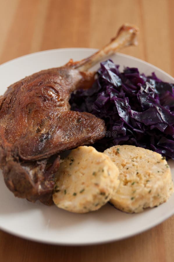 Roasted goose leg with braised red cabbage and dumplings. Roasted goose leg with braised red cabbage and dumplings
