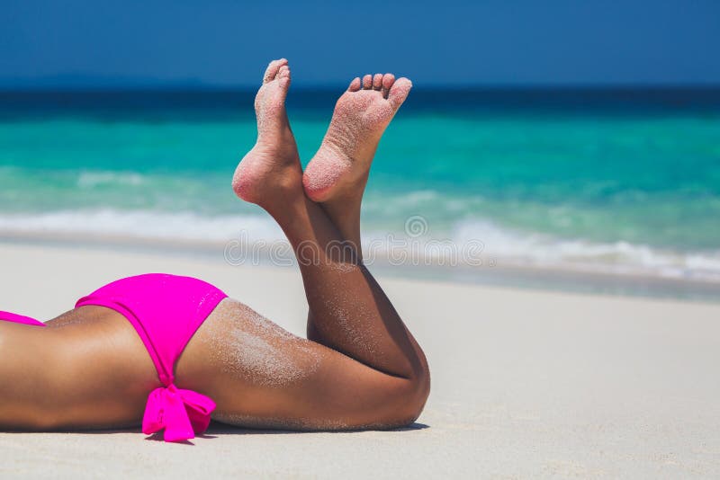 Piernas atractivas de la mujer en bikini rosado fotografía de archivo libre de regalías Piernas atractivas de la mujer en bikini rosado fotografía de archivo libre de regalías
