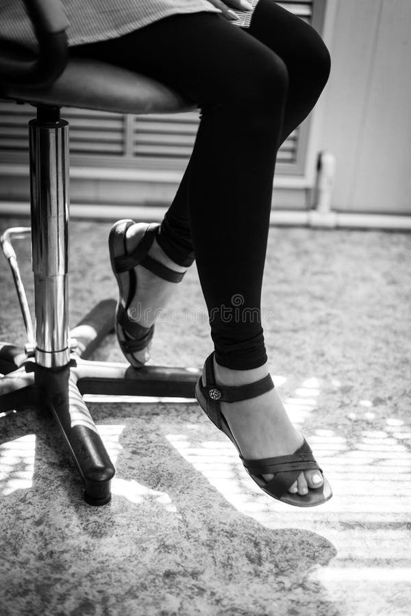 Piernas de la muchacha en las sandalias que se sientan en una silla Foto blanco y negro de Pek?n, China muchacha en sandalias imagen de archivo Piernas de la muchacha en las sandalias que se sientan en una silla Foto blanco y negro de Pek?n, China muchacha en sandalias imagen de archivo