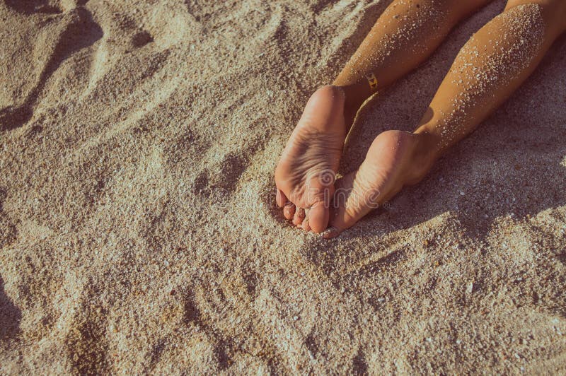 Piernas de la mujer en la playa de la arena fotografía de archivo libre de regalías Piernas de la mujer en la playa de la arena fotografía de archivo libre de regalías