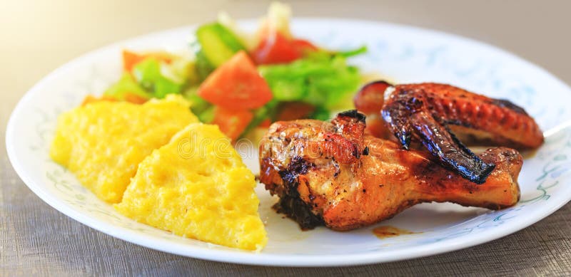 Piernas de pollo, Polenta o Mamaliga y ensalada cocidos en placa de lujo Comida tradicional y cultura culinaria específicas para fotos de archivo Piernas de pollo, Polenta o Mamaliga y ensalada cocidos en placa de lujo Comida tradicional y cultura culinaria específicas para fotos de archivo