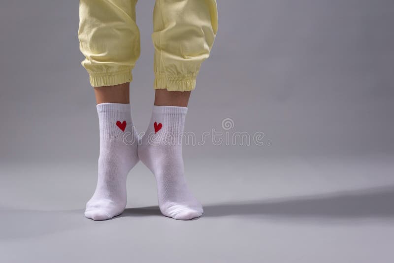 legs of a young girl with white socks with a saddle. On a gray background. legs of a young girl with white socks with a saddle. On a gray background.