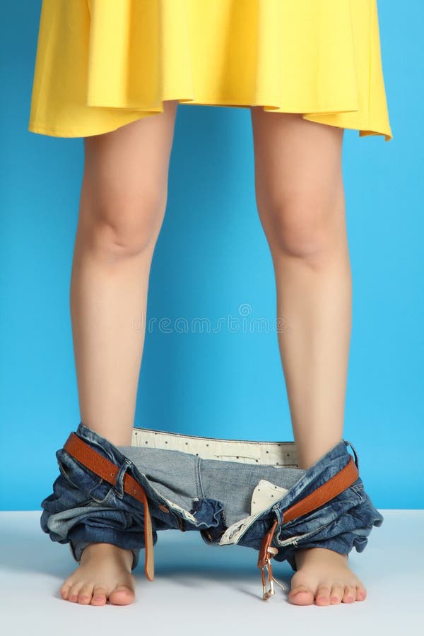 Piernas en vaqueros y un vestido foto de archivo libre de regalías