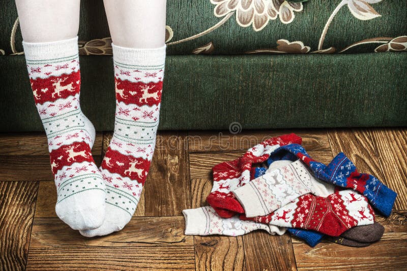 Christmas female legs in socks on the background of the parquet floor. vignette for artistic effect. Christmas female legs in socks on the background of the parquet floor. vignette for artistic effect