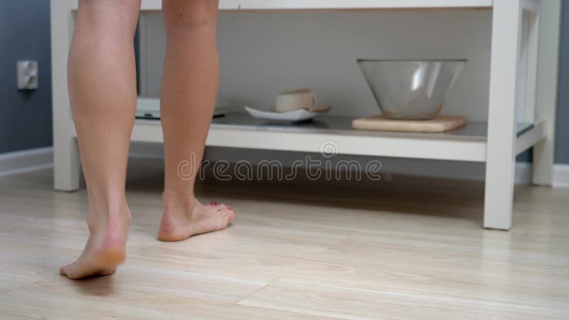 Piernas femeninas entrando al baño por la mañana