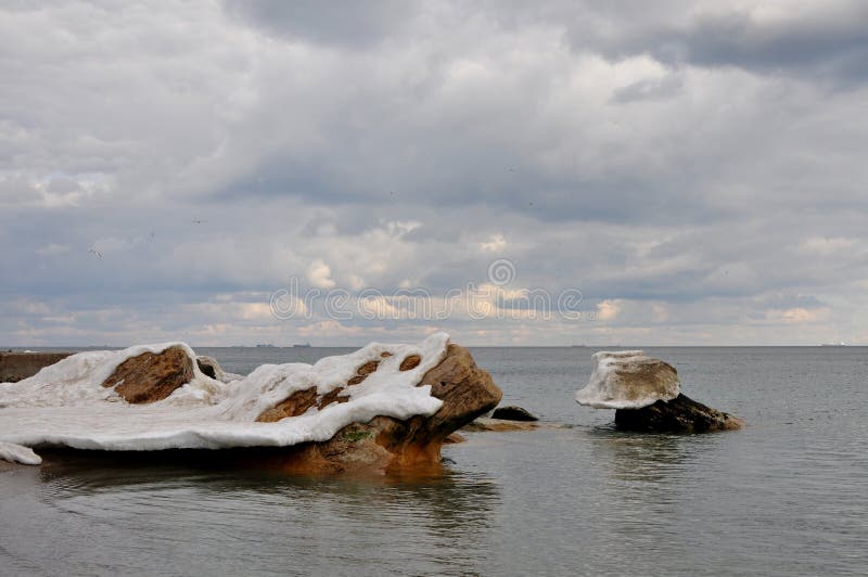 Pierres côtières dans le piaulement de la Mer Noire de dessous les croissances de la neige et de la glace de fonte photos stock Pierres côtières dans le piaulement de la Mer Noire de dessous les croissances de la neige et de la glace de fonte photos stock