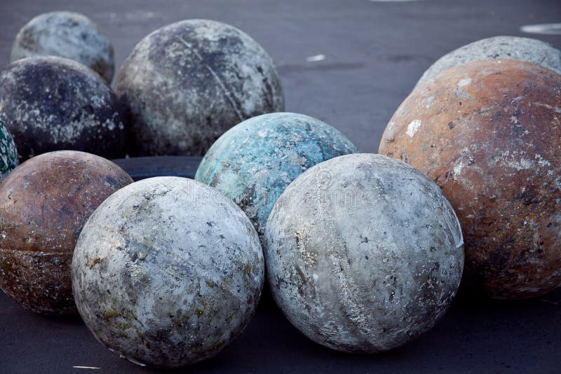 A collection of well used atlas stones of varying sizes, used in strength training practice & competitions, outdoors in a shaded yard. A collection of well used atlas stones of varying sizes, used in strength training practice & competitions, outdoors in a shaded yard.