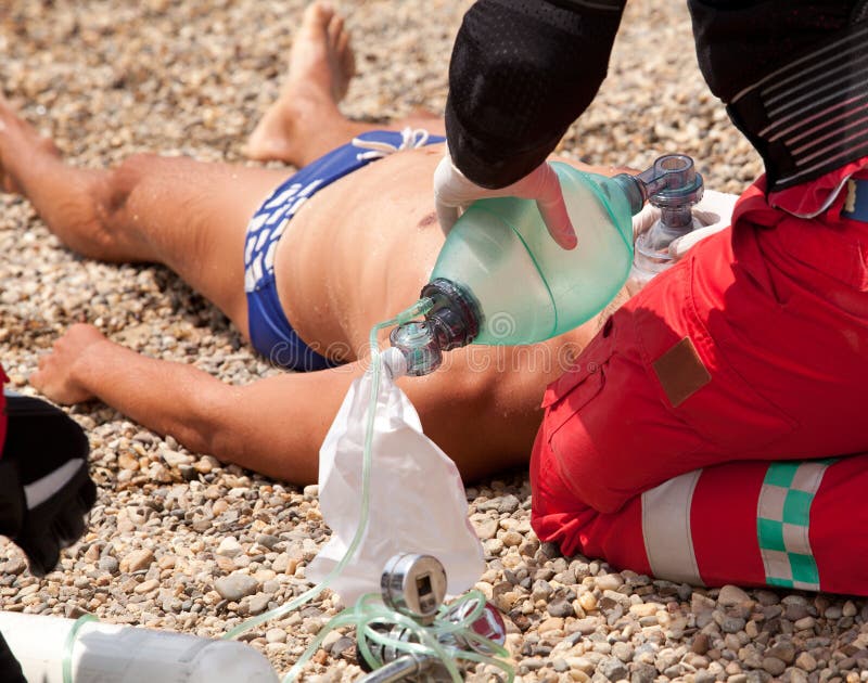 First aid instructor demonstrating artificial respiration using respirator after drowning. First aid instructor demonstrating artificial respiration using respirator after drowning