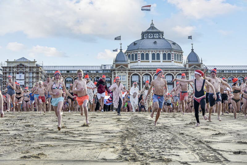 SCHEVENINGEN, 1 January 2018 - Dutch people following the strong tradition of the first new year dive run toward the frozen North Sea water after the midday ring bells on The Hague beach. SCHEVENINGEN, 1 January 2018 - Dutch people following the strong tradition of the first new year dive run toward the frozen North Sea water after the midday ring bells on The Hague beach