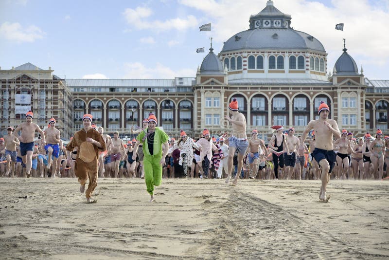 SCHEVENINGEN, 1 January 2018 - Dutch people following the strong tradition of the first new year dive run toward the frozen North Sea water after the midday ring bells on The Hague beach. SCHEVENINGEN, 1 January 2018 - Dutch people following the strong tradition of the first new year dive run toward the frozen North Sea water after the midday ring bells on The Hague beach